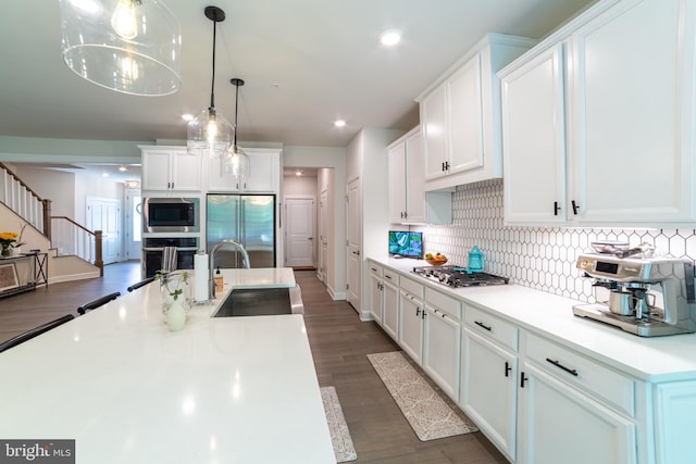 233 W Ponds Edge Dr, Media, PA 19063 - kitchen with stainless steel appliances, a sink, light countertops, white cabinetry, and backsplash