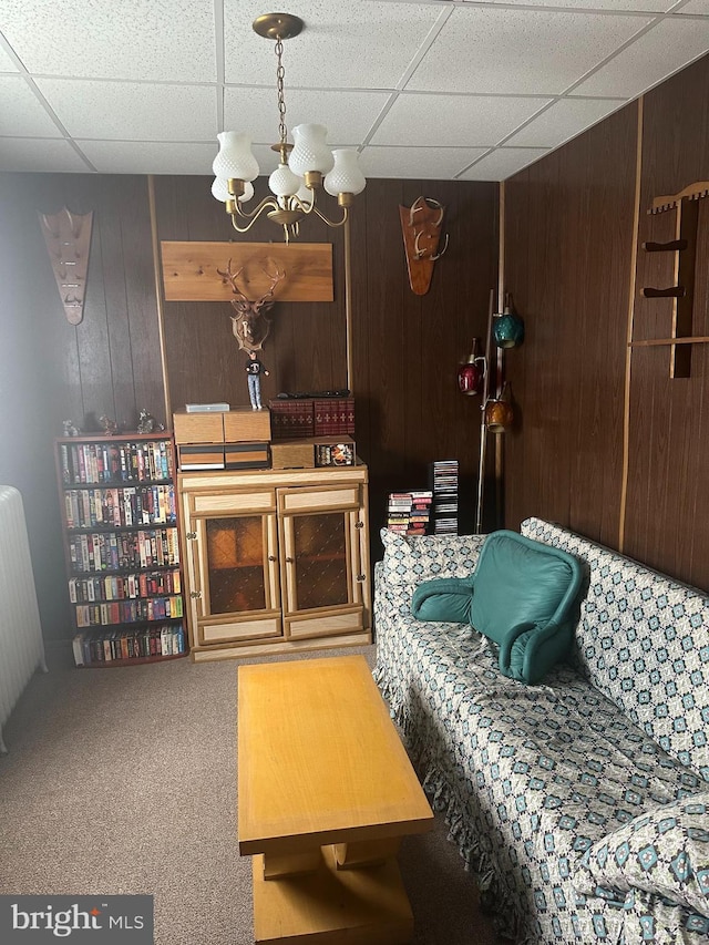 409 S Balliet St, Frackville, PA 17931 - carpeted living area with wood walls, a chandelier, and a paneled ceiling