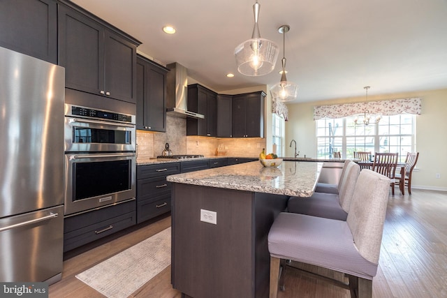 2038 Morgan Creek Dr, Quakertown, PA 18951 - kitchen with appliances with stainless steel finishes, wall chimney exhaust hood, a kitchen bar, light stone counters, and decorative backsplash