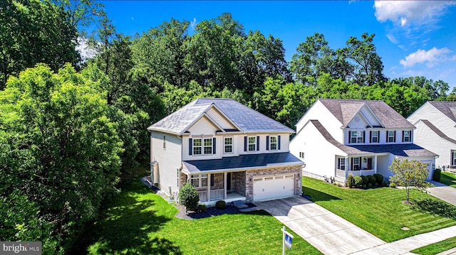 1530 Swearingen Dr, Bel Air, MD 21014 - view of front facade with a porch, concrete driveway, an attached garage, stone siding, and a front yard