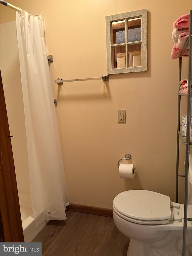 425 Beechcroft Rd, Winchester, VA 22601 - bathroom featuring wood finished floors, a shower with shower curtain, toilet, and baseboards
