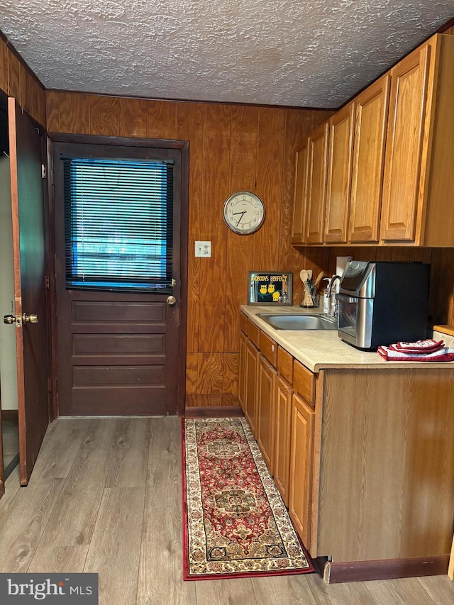425 Beechcroft Rd, Winchester, VA 22601 - kitchen featuring a sink, light wood-type flooring, brown cabinets, a textured ceiling, and light countertops