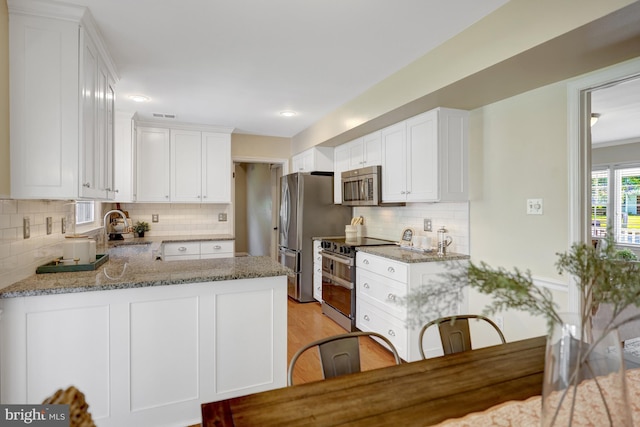 4212 Penner Ln, Fairfax, VA 22033 - kitchen with appliances with stainless steel finishes, a sink, light stone counters, tasteful backsplash, and white cabinets