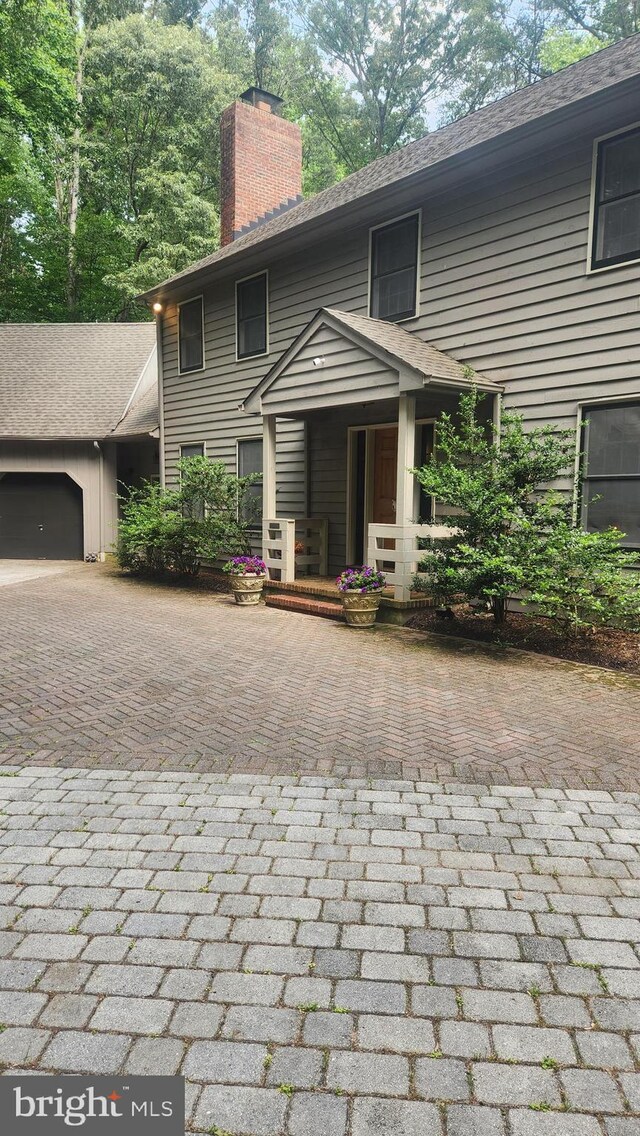 2317 Nancarles Dr, Gambrills, MD 21054 - view of front of home featuring decorative driveway, a chimney, and a garage