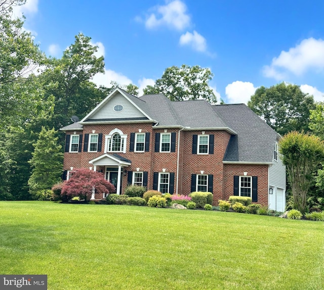 6000 Clairemont Dr, Owings, MD 20736 - colonial house with brick siding, a front yard, a garage, and a shingled roof