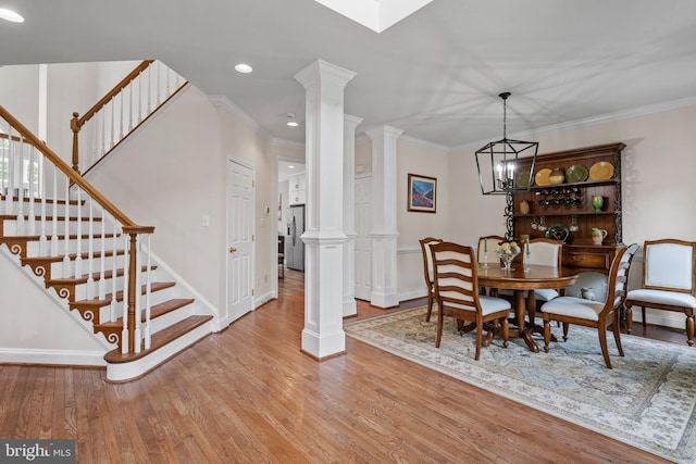 6000 Clairemont Dr, Owings, MD 20736 - dining room with ornate columns, wood finished floors, stairs, baseboards, and recessed lighting