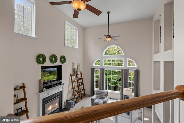 6000 Clairemont Dr, Owings, MD 20736 - carpeted living area with ceiling fan, a towering ceiling, and a glass covered fireplace
