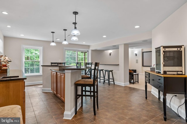 6000 Clairemont Dr, Owings, MD 20736 - kitchen with a breakfast bar area, dark countertops, baseboards, pendant lighting, and recessed lighting