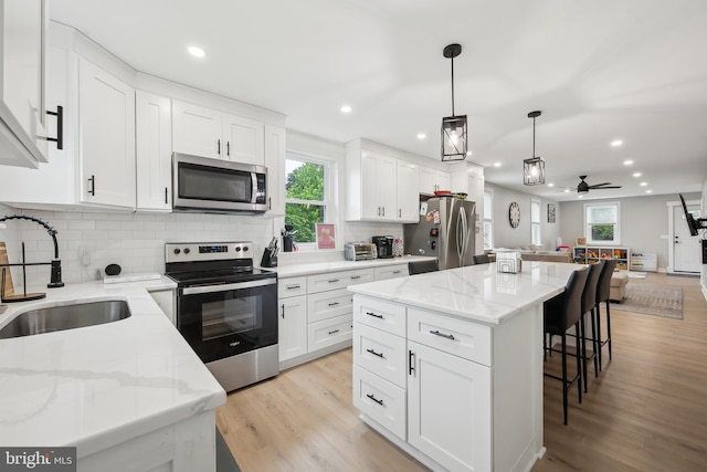 330 Date St, Warminster, PA 18974 - kitchen featuring stainless steel appliances, a sink, open floor plan, a kitchen bar, and decorative backsplash