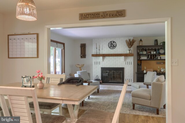 46 Gelsinger Rd, Reading, PA 19608 - dining room with a brick fireplace, wood finished floors, and a chandelier