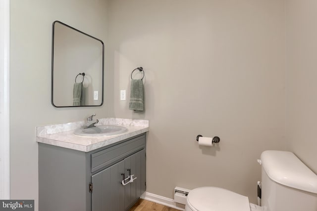 46 Gelsinger Rd, Reading, PA 19608 - half bath with toilet, a baseboard radiator, vanity, and wood finished floors