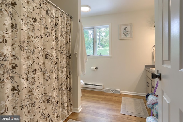 46 Gelsinger Rd, Reading, PA 19608 - bathroom featuring a baseboard heating unit, toilet, vanity, wood finished floors, and baseboards