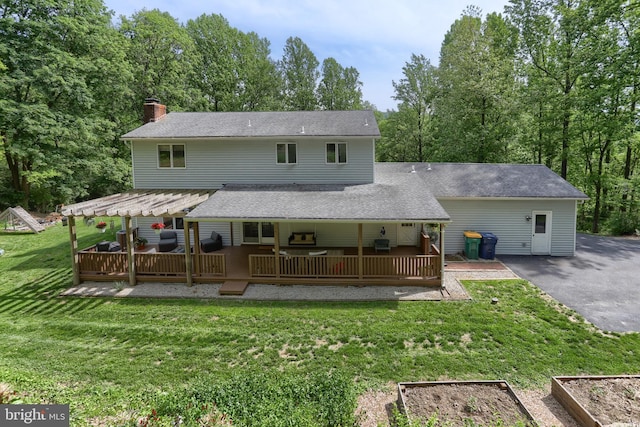 46 Gelsinger Rd, Reading, PA 19608 - back of property featuring a yard, a vegetable garden, a chimney, and a deck