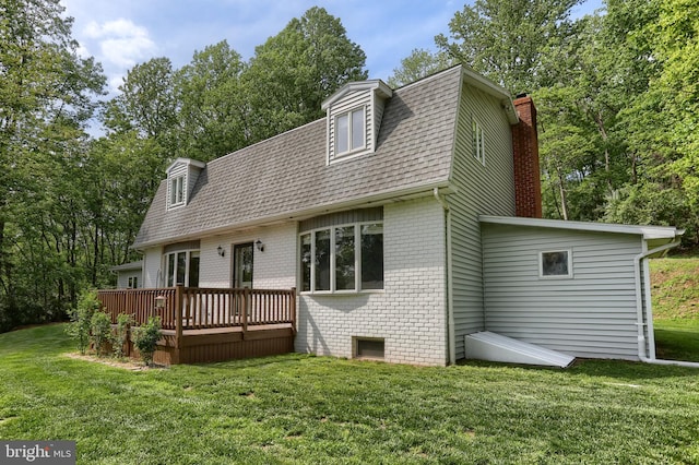 46 Gelsinger Rd, Reading, PA 19608 - back of property featuring brick siding, a deck, a gambrel roof, a lawn, and a chimney