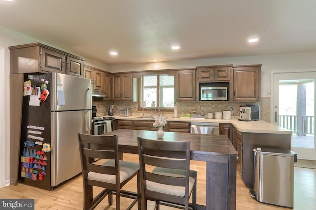 46 Gelsinger Rd, Reading, PA 19608 - kitchen with appliances with stainless steel finishes, a sink, a peninsula, under cabinet range hood, and light wood-style flooring