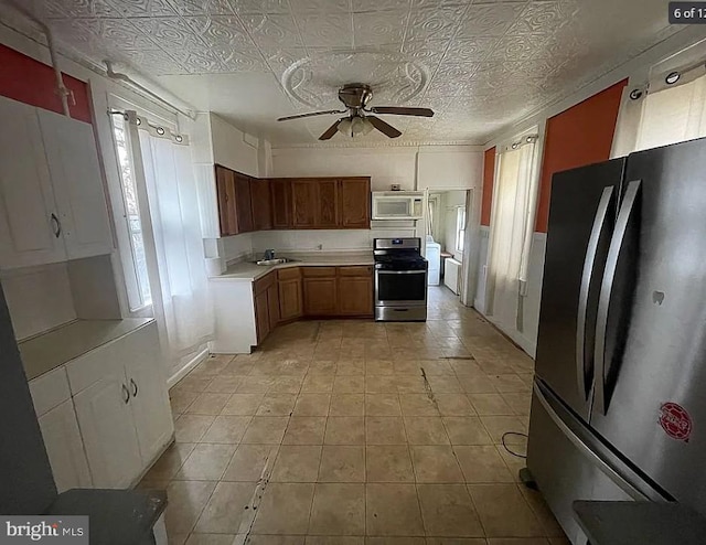 911 N Lehigh St, Baltimore, MD 21205 - kitchen featuring freestanding refrigerator, stainless steel stove, white microwave, ceiling fan, and light countertops