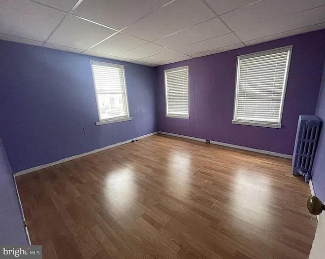 911 N Lehigh St, Baltimore, MD 21205 - spare room featuring a paneled ceiling, wood finished floors, baseboards, and radiator