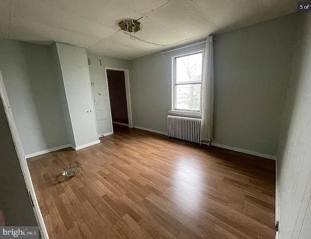 911 N Lehigh St, Baltimore, MD 21205 - unfurnished room featuring radiator heating unit, wood finished floors, and baseboards