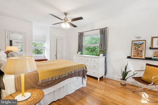 5721 Greenspring Ave, Baltimore, MD 21209 - bedroom with multiple windows, light wood-type flooring, and baseboards
