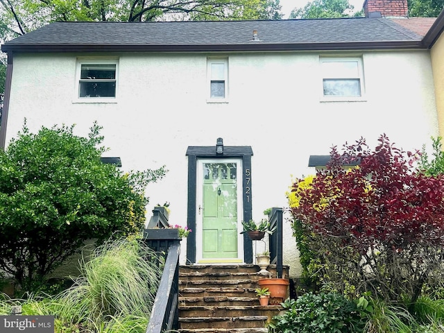 5721 Greenspring Ave, Baltimore, MD 21209 - property entrance with stucco siding, roof with shingles, and a chimney