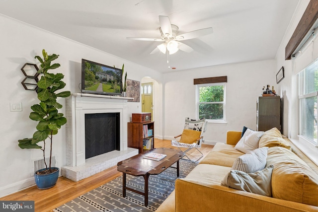 5721 Greenspring Ave, Baltimore, MD 21209 - living area featuring arched walkways, wood finished floors, plenty of natural light, and a brick fireplace