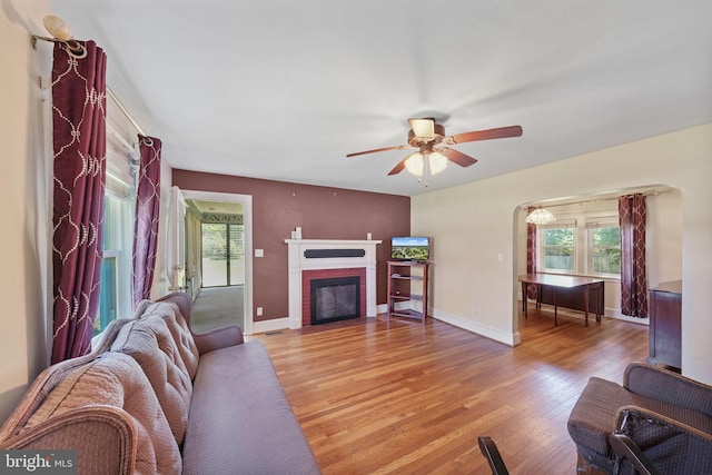 301 Hamilton Blvd, Warsaw, VA 22572 - living room with light wood-type flooring, a brick fireplace, ceiling fan, and baseboards