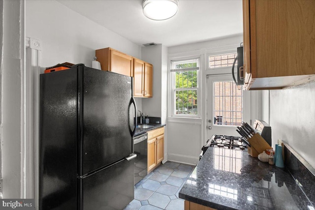 233 Rhode Island Ave NW, Washington, DC 20001 - kitchen with freestanding refrigerator, dishwashing machine, a sink, baseboards, and dark stone countertops