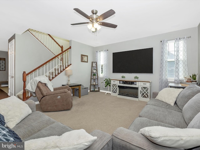 1419 Ramblewood Dr, Emmitsburg, MD 21727 - carpeted living room featuring a ceiling fan, stairs, a glass covered fireplace, and baseboard heating