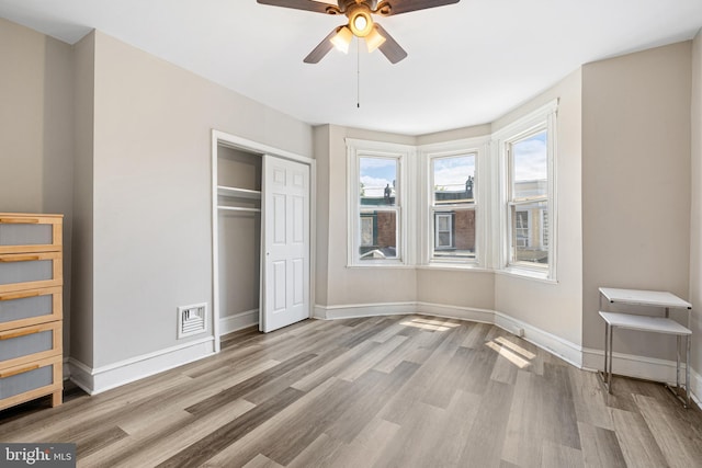 2729 W Seltzer St, Philadelphia, PA 19132 - unfurnished bedroom with multiple windows, wood finished floors, a closet, and baseboards