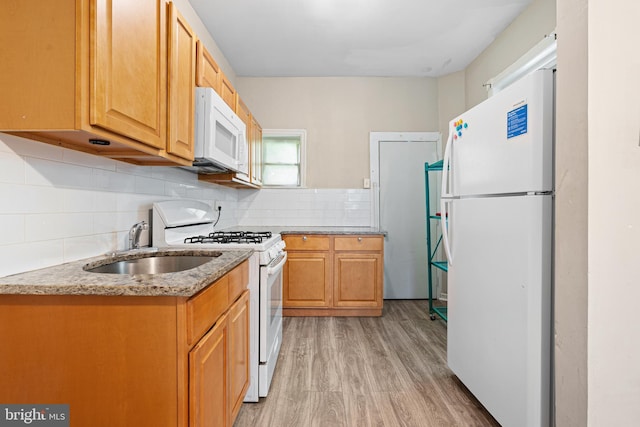 2729 W Seltzer St, Philadelphia, PA 19132 - kitchen with white appliances, light wood-type flooring, a sink, and backsplash