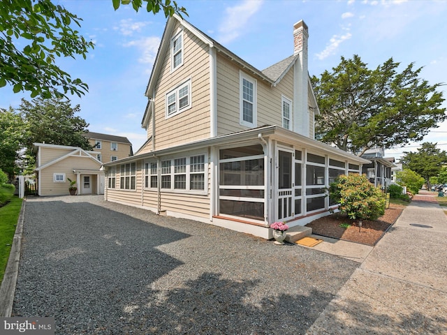 16 Delaware Ave, Rehoboth Beach, DE 19971 - view of property exterior with a sunroom and a chimney