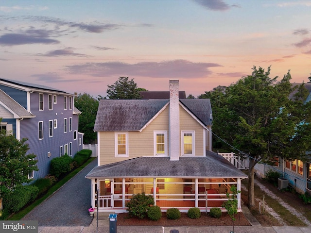 16 Delaware Ave, Rehoboth Beach, DE 19971 - view of front facade with roof with shingles, a chimney, and central AC