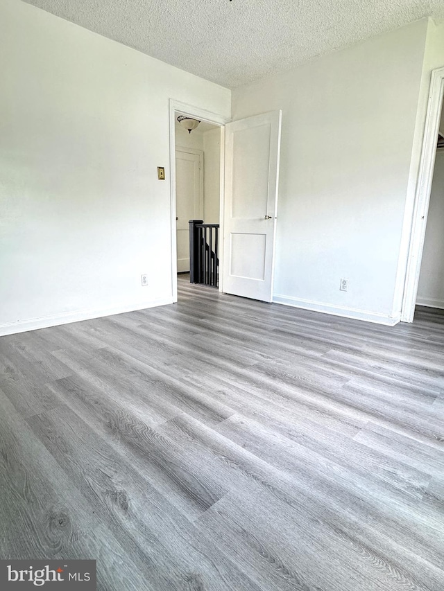4137 Passmore St, Philadelphia, PA 19135 - unfurnished bedroom with a textured ceiling, wood finished floors, and baseboards
