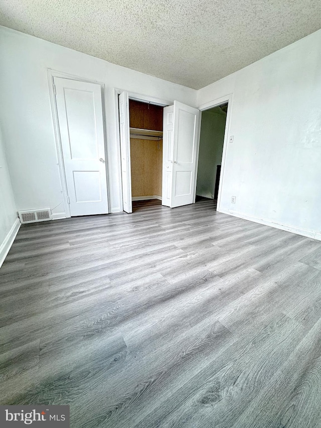 4137 Passmore St, Philadelphia, PA 19135 - unfurnished bedroom with a textured ceiling, wood finished floors, baseboards, and a closet