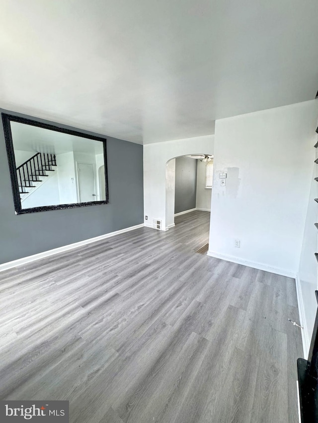 4137 Passmore St, Philadelphia, PA 19135 - unfurnished room with wood finished floors, arched walkways, and baseboards