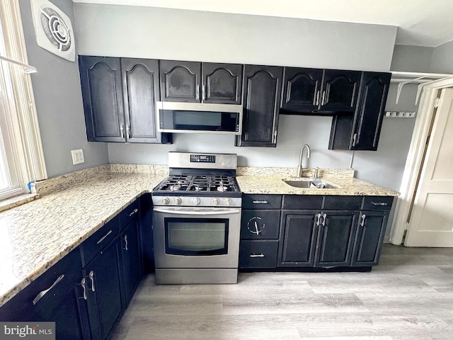 4137 Passmore St, Philadelphia, PA 19135 - kitchen featuring appliances with stainless steel finishes, light wood finished floors, a sink, and blue cabinets