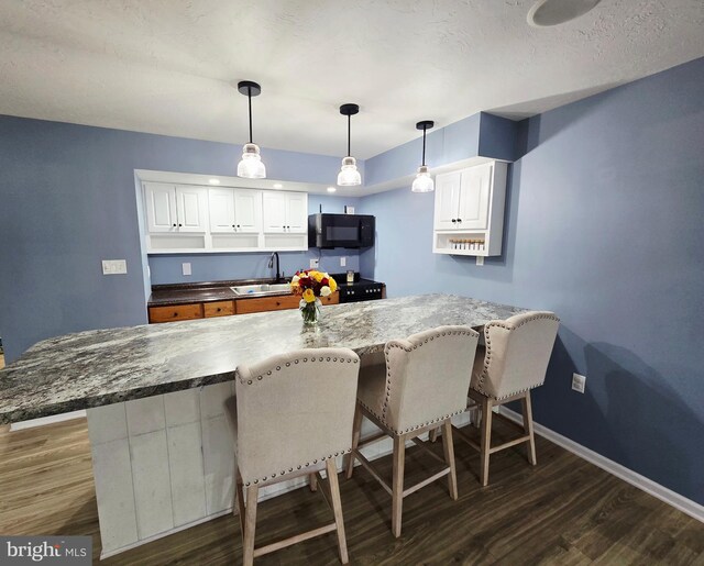 7677 Green Ridge Ln, Abbottstown, PA 17301 - kitchen featuring black microwave, a sink, dark wood-style flooring, and a breakfast bar