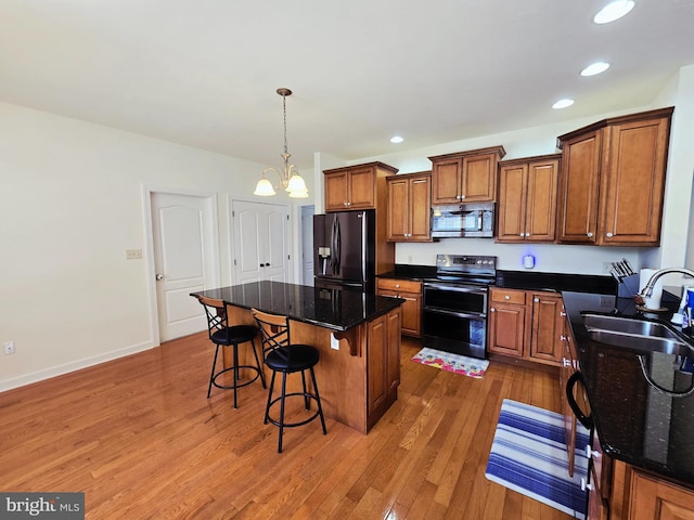 7677 Green Ridge Ln, Abbottstown, PA 17301 - kitchen featuring range with two ovens, black refrigerator with ice dispenser, stainless steel microwave, a sink, and brown cabinetry