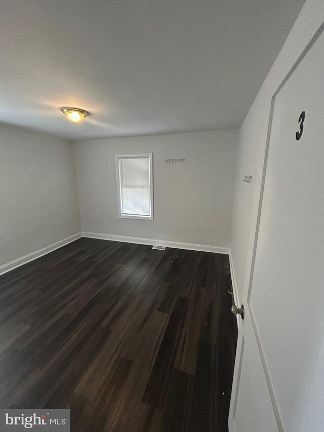 5258 Saint Charles Ave, Baltimore, MD 21215 - spare room with dark wood-style flooring and baseboards