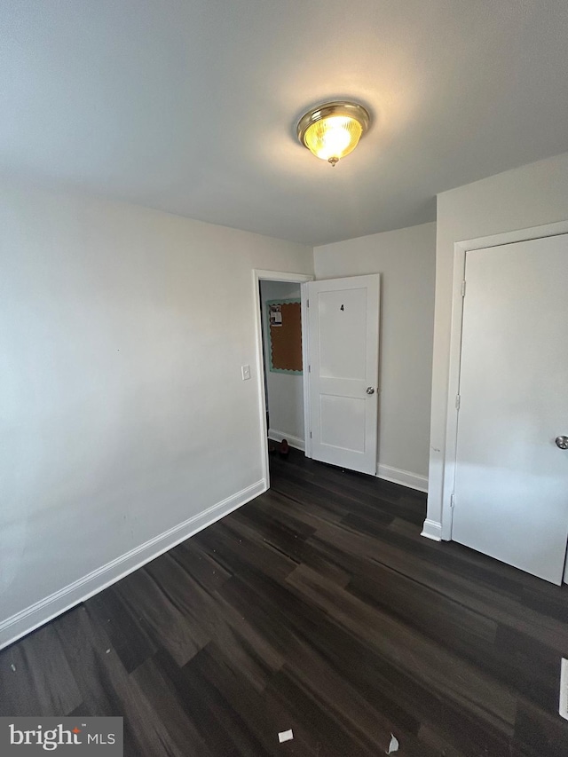 5258 Saint Charles Ave, Baltimore, MD 21215 - unfurnished bedroom featuring baseboards and dark wood-style flooring
