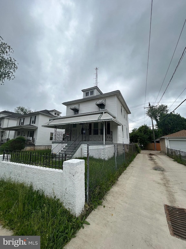 5258 Saint Charles Ave, Baltimore, MD 21215 - view of front of house with a fenced front yard, a porch, and driveway