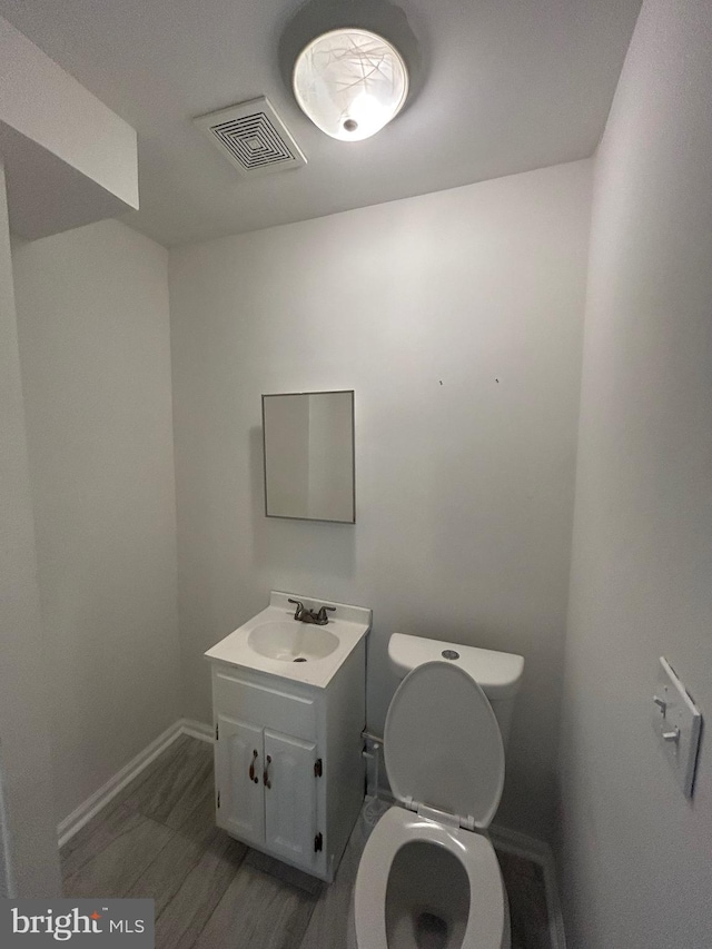 5258 Saint Charles Ave, Baltimore, MD 21215 - bathroom featuring vanity, toilet, baseboards, and wood finished floors