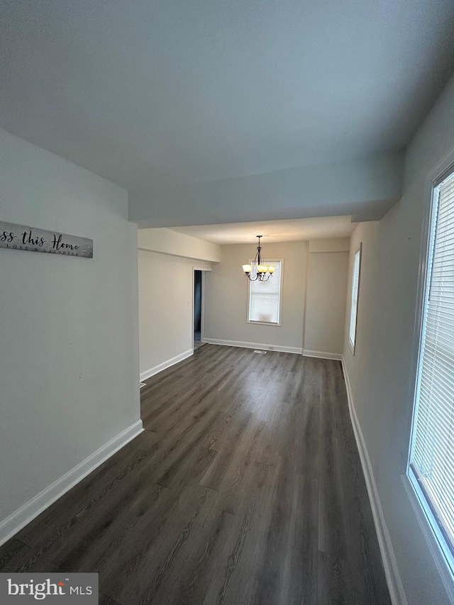 5258 Saint Charles Ave, Baltimore, MD 21215 - spare room featuring a chandelier, dark wood-style floors, baseboards, and plenty of natural light