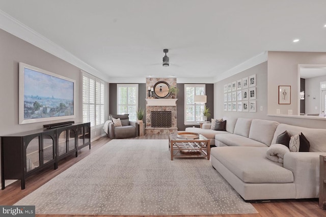 42863 Glyndebourne Ct, Broadlands, VA 20148 - living room featuring wood finished floors, crown molding, ceiling fan, a stone fireplace, and recessed lighting