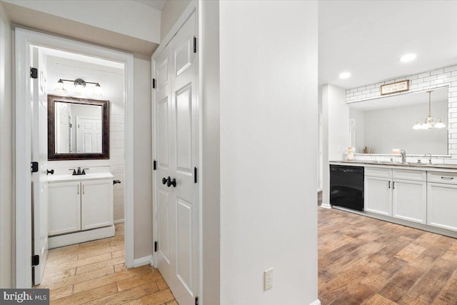 6816 Balmoral Ct, New Market, MD 21774 - hall featuring a sink, light wood-type flooring, recessed lighting, baseboards, and a chandelier