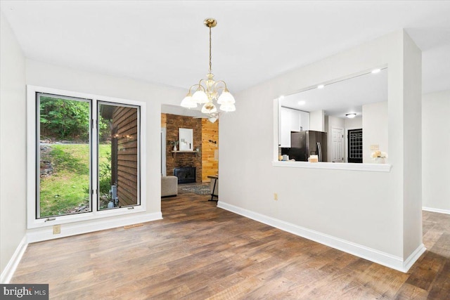 6816 Balmoral Ct, New Market, MD 21774 - unfurnished dining area with baseboards, wood finished floors, a chandelier, and a stone fireplace