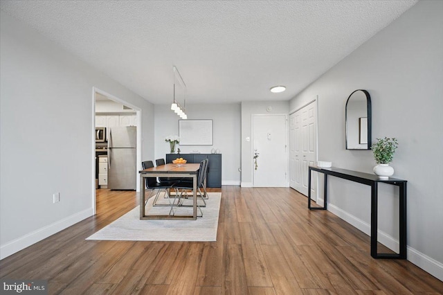 666 W Germantown Pike Unit 1706, Plymouth Meeting, PA 19462 - dining room featuring wood finished floors, baseboards, and a textured ceiling