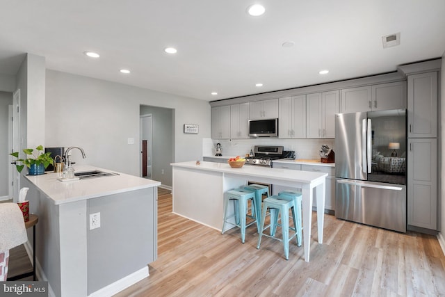 120 Dollie Mae Ln, Stephens City, VA 22655 - kitchen with stainless steel appliances, a sink, gray cabinetry, a kitchen bar, and recessed lighting