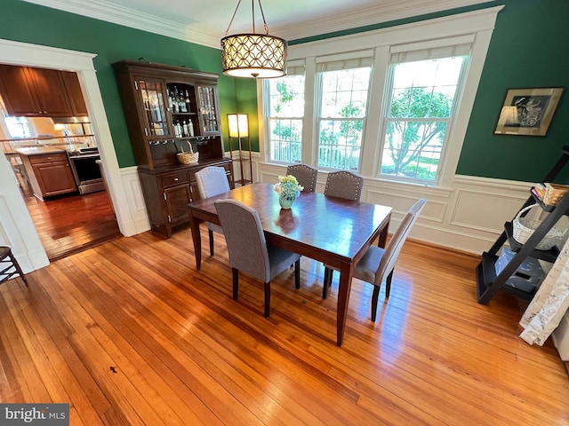 6206 Pinehurst Rd, Baltimore, MD 21212 - dining room with a wainscoted wall, light wood-style flooring, a decorative wall, and crown molding