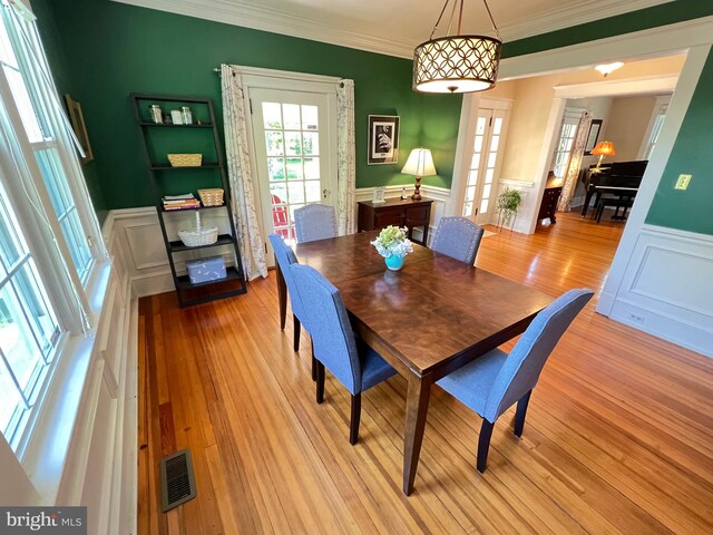 6206 Pinehurst Rd, Baltimore, MD 21212 - dining area with wainscoting, crown molding, a decorative wall, and light wood-style flooring